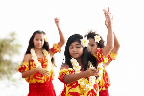 Three young Hawaiian girls present a Hula story at a Luau